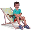 A young boy is sitting on a child's deck chair with a horse and horseshoe pattern. Podgląd zdjęcia produktu