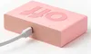 A pink Lexon Flip Classic alarm clock is shown with a USB cable plugged into its side. Náhled obrázku produktu
