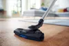 A vacuum cleaner head is shown cleaning a wooden floor in a living room. Produktbild-Vorschau