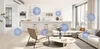 A modern living room and kitchen area with a sofa, coffee table, chair, and kitchen island. Several blue spheres are overlaid on the image. Produktbild-Vorschau