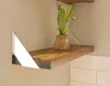 A wooden shelf with a white bracket and a small potted plant. Produktbild-Vorschau