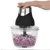 A person's hand is pressing down on the lid of a food chopper containing chopped red onions. Produktbild-Vorschau