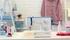 A sewing machine is displayed on a table with various sewing supplies in the background. Produktbild-Vorschau