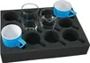 A black foam insert with multiple circular cutouts, holding two blue and white cups and two clear glasses. Náhled obrázku produktu