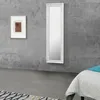 A bedroom scene with a mirror and a framed picture on a concrete wall. Voir les images du produit
