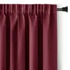 A close-up view of a burgundy blackout curtain hanging from a curtain rod.