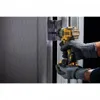 A person wearing protective gloves is using a DeWalt cordless drill to attach a hinge to a metal door frame. Produktbild-Vorschau