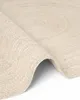 A close-up, angled view of a round jute rug with a braided texture and a spiral pattern. Anteprima dell’immagine prodotto