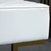 Close-up view of a white tufted bench with a gold metal base. Náhľad obrázku produktu