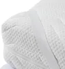 A close-up view of a white mattress topper with a quilted texture and an elastic strap. Produktbild-Vorschau