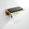 A gold toilet paper holder with a shelf for a phone, mounted on a white wall. Anteprima dell’immagine prodotto