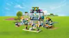 A LEGO Friends Stephanies Sportstadion playset is set up on a green grassy field with a blue sky and clouds in the background. Podgląd zdjęcia produktu