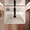 A top-down view of a modern bathroom sink with a black faucet. Produktbild-Vorschau