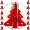 A red felt Christmas tree shaped cutlery holder with cut-out stars, holding a fork and knife, placed on a white plate. Podgląd zdjęcia produktu