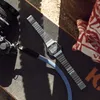 A vintage digital watch and camera lens are placed on a skateboard. Podgląd zdjęcia produktu