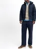 A man wearing a navy winter jacket, tan sweater, and blue shirt stands against a white background. Produktbild-Vorschau