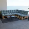 A sectional sofa made of wooden pallets with blue cushions, placed on a balcony overlooking the ocean. Voir les images du produit