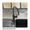 A black kitchen faucet is shown in a modern kitchen sink, with a window in the background. Produktbild-Vorschau