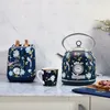 A floral-patterned kettle, toaster, and mug set on a marble countertop. Produktbild-Vorschau