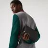 A man is holding a black clutch bag. Produktbild-Vorschau