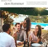 People enjoying a meal outdoors under a large green umbrella near a swimming pool. Náhled obrázku produktu