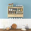 A wooden kitchen shelf filled with various kitchen items, mounted on a blue wall above a tiled backsplash. Náhled obrázku produktu
