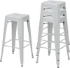 Two white metal bar stools are shown against a white background. One stool is in the foreground on the left, and a stack of three stools is in the foreground on the right. Náhled obrázku produktu