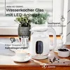 A white electric kettle with a glass body and LED display is shown on a wooden surface, next to a cup of coffee and coffee beans. Produktbild-Vorschau