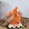 A plush hen sitting in a basket on an egg carton. Produktbild-Vorschau