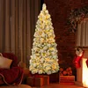 A decorated Christmas tree with lights and presents in a cozy room setting. Podgląd zdjęcia produktu