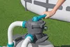 A person's hand is shown adjusting a valve on a pool pump filter system next to an above-ground swimming pool. Produktbild-Vorschau
