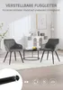Two dark gray upholstered chairs with black metal legs are placed around a black coffee table in a well-lit room with white walls and decorative elements. Produktbild-Vorschau
