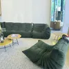 A modern living room with green modular sofas and coffee tables. Voir les images du produit