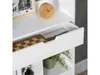 A close-up view of a white shelf unit, showing an open drawer with a chessboard inside, a small wooden clock, and a potted plant. Náhľad obrázku produktu