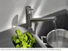 A kitchen sink with a faucet running water into a pot, and a bunch of mint leaves in the sink. Anteprima dell’immagine prodotto