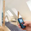 A person is holding a Bosch laser distance measurer in an attic room that is under renovation. Voir les images du produit