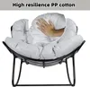 A hand pressing into a plush gray cushion of a black metal rocking chair. Produktbild-Vorschau