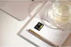 A close-up shot of a Lexar SDXC memory card, a pen, and a glass of water on a book. Náhled obrázku produktu
