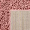 A close-up view of the corner of a shaggy rug, showing both the pile and the backing. Produktbild-Vorschau