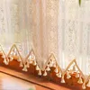 A close-up view of a lace curtain with tassels hanging down. Anteprima dell’immagine prodotto