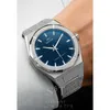A close-up shot of a watch on a person's wrist, with a white shirt sleeve visible. Produktbild-Vorschau