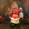 A Christmas-themed figurine of a girl holding a lantern in front of a fireplace. Produktbild-Vorschau