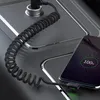A coiled USB-C cable is plugged into a smartphone, which is charging in a car's center console. Anteprima dell’immagine prodotto
