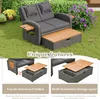 A rattan garden lounge set with a coffee table, displayed outdoors on grass with plants in the background. Podgląd zdjęcia produktu