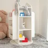 A white rotating bookshelf filled with toys and stuffed animals in a room with a large teddy bear and a grey carpet. Podgląd zdjęcia produktu