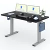 A black height-adjustable desk with dual monitors, keyboard, mouse, headphones, a cup of coffee, and a briefcase hanging from the side. Produktbild-Vorschau