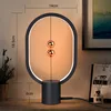 A modern magnetic levitation lamp on a wooden desk. Produktbild-Vorschau