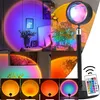 A collage of images showcasing a sunset lamp in various settings and color projections, along with a remote control. Podgląd zdjęcia produktu