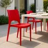 Outdoor dining setting with red chairs and a white table. Produktbild-Vorschau