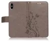 A gray flip phone case with a floral and butterfly embossed design. Produktbild-Vorschau
